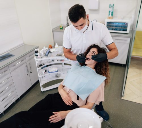 dentist-performing-check-up-woman (1) (1)